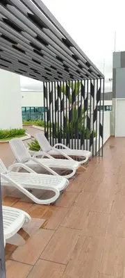 a row of white chaise lounges on a patio at DeRose Homestay, Pekan Ipoh in Ipoh