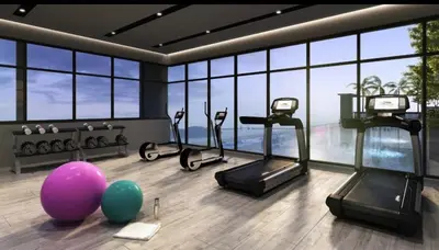 a gym with cardio machines and balloons in a room with windows at Wanderlust Retreat in Bayan Lepas