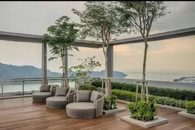 a living room with couches and trees on a balcony at Wanderlust Retreat in Bayan Lepas