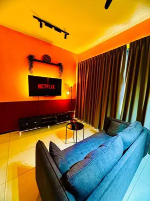 a living room with a couch and a television at Spacious3BR 12-PaxApartmentStunning Sea &CityViews in Jelutong