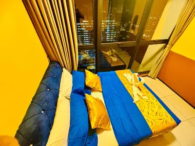 a bed in front of a window in a room at Deluxe Suites with Infinity Pool, Kids' Pool & Sea in Jelutong