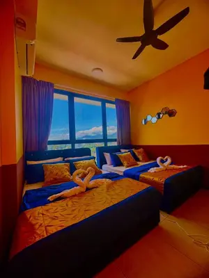 two beds in a room with a ceiling fan at Deluxe Suites with Infinity Pool, Kids' Pool & Sea in Jelutong