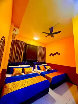 a room with two beds and a tv in it at Deluxe Suites with Infinity Pool, Kids' Pool & Sea in Jelutong