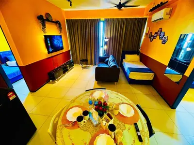 a living room with a table and a couch at Deluxe Suites with Infinity Pool, Kids' Pool & Sea in Jelutong