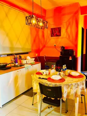 a kitchen with a table with a yellow and red wall at Deluxe Suite for10 Stunning Sea &City ViewsNetflix in Jelutong