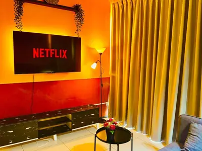 a living room with a television on a wall at Deluxe Suite for10 Stunning Sea &City ViewsNetflix in Jelutong