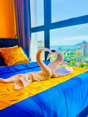 two flamingos sitting on a bed in a window at Deluxe Suite for10 Stunning Sea &City ViewsNetflix in Jelutong