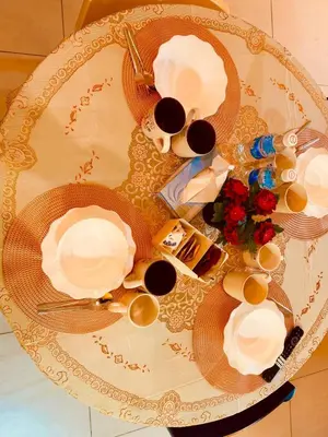 a table with plates and cups and flowers on it at Deluxe Suite for10 Stunning Sea &City ViewsNetflix in Jelutong
