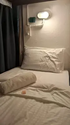 a bed with a pillow and a towel on it at 39 Love Lane - Smart Intelligent Inn Georgetown in George Town