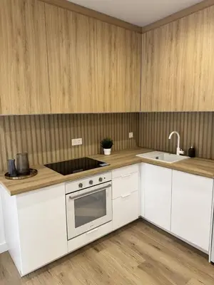 a kitchen with white cabinets and a stove and a sink at Penginapan Jolra S3 in Sungai Petani