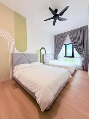 two beds in a bedroom with a ceiling fan at The Horizon Retreat in Ipoh