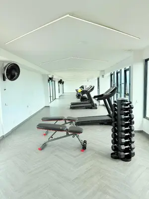 a gym with several tread machines in a row at The Horizon Retreat in Ipoh