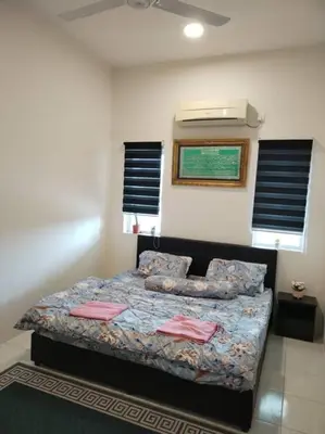 a bedroom with a bed in a room with windows at A to Z Homestay in Sitiawan