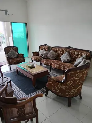 a living room with a couch and chairs and a table at A to Z Homestay in Sitiawan