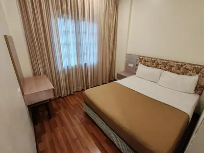 a bedroom with a large bed and a window at Iris House Resort & Apartment Cameron Highlands in Cameron Highlands