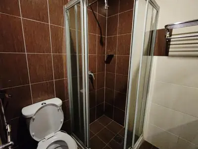 a bathroom with a toilet and a glass shower at Iris House Resort & Apartment Cameron Highlands in Cameron Highlands