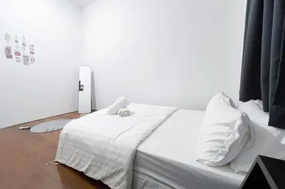 a bed with white sheets and pillows in a room at Homestay Taman Canning Ipoh, Perak - Smarthome in Ipoh