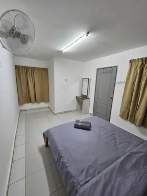 a bedroom with a bed and a fan in it at Rain Forest Hostel in Ipoh