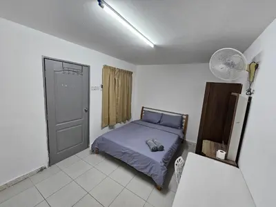 a bedroom with a bed and a fan and a door at Rain Forest Hostel in Ipoh