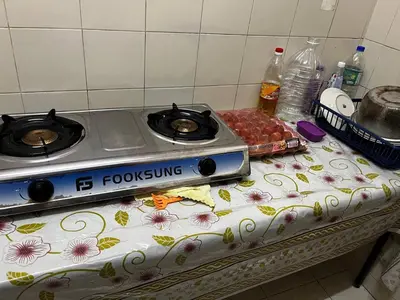 a stove top oven sitting on a table at Homestay Seri Aishah in Chemor