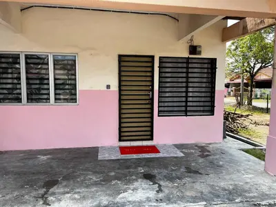 a pink house with a red door and windows at Homestay Seri Aishah in Chemor