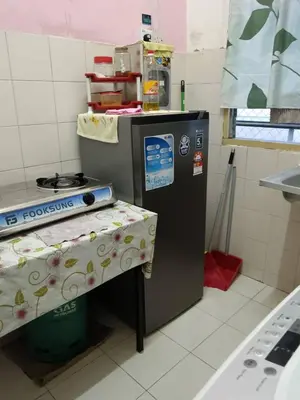 a small kitchen with a table and a machine at Homestay Seri Aishah in Chemor