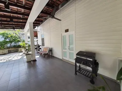 a porch with a grill on the side of a house at Lisa Countryside Homestay in Ayer Tawar