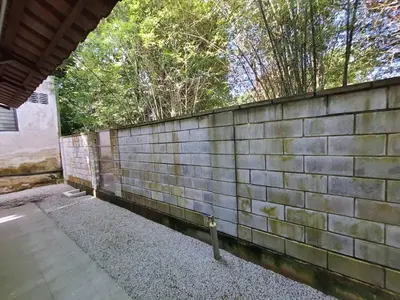 a brick wall with trees in the background at Lisa Countryside Homestay in Ayer Tawar