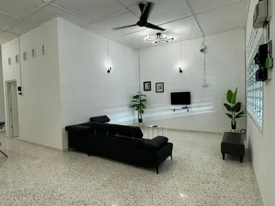 a living room with a black couch and a tv at Yipstay Gopeng HomeTown in Gopeng