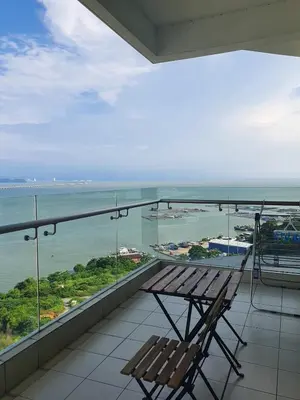 a bench on a balcony with a view of the ocean at Southbay Seaview Condo A23 #10minQueensbay in Bayan Lepas