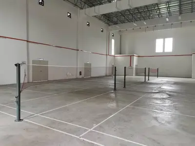 an empty tennis court with a net in a building at myuu homestay in Ipoh