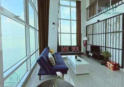 a living room with a blue couch and some windows at Maritime Sea View Duplex in George Town