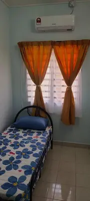 a bedroom with a bed and two windows with curtains at Chill Spot Homestay in Ipoh