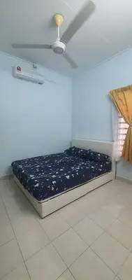 a bed in a room with a ceiling fan at Chill Spot Homestay in Ipoh