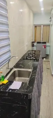 a kitchen with a black counter top and a sink at Chill Spot Homestay in Ipoh
