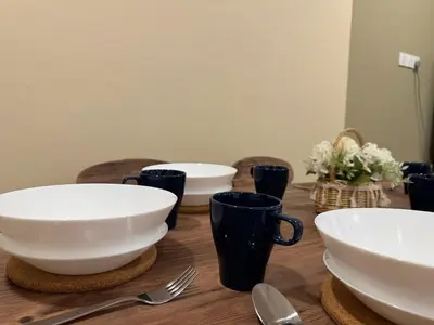 a wooden table with bowls and utensils on it at NEW-Serene Home Juru Sentral Icon City in Bukit Mertajam
