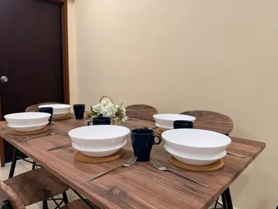 a wooden table with bowls and utensils on it at NEW-Serene Home Juru Sentral Icon City in Bukit Mertajam