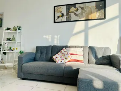 a living room with a blue couch with pillows on it at 2BR Georgetown Luxury Suite #RooftopPool #Beacon in George Town
