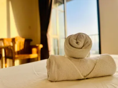 a stack of towels sitting on top of a bed at Elegant 2BR Luxury Suite in Haaven in George Town