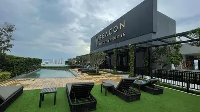 a hotel with a pool and chairs and a sign at Haven Luxury 2BR Suite with Stunning Views in George Town