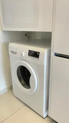 a washing machine in a kitchen next to a refrigerator at Haven Luxury 2BR Suite with Stunning Views in George Town
