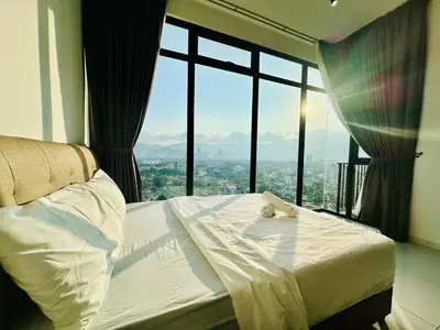 a bed in a room with a large window at Spacious 2BR Suite for 5-7 pax in George Town