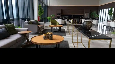a living room with a couch and tables and chairs at Stunning 2BR with Infinity Pool & City Views in George Town