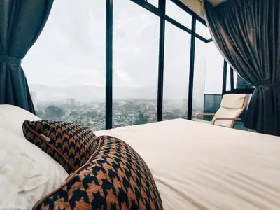 a bed in a room with a large window at Stunning 2BR with Infinity Pool & City Views in George Town