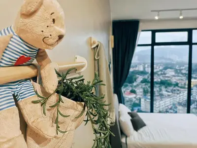 a teddy bear in a hotel room with a plant at Stunning 2BR with Infinity Pool & City Views in George Town