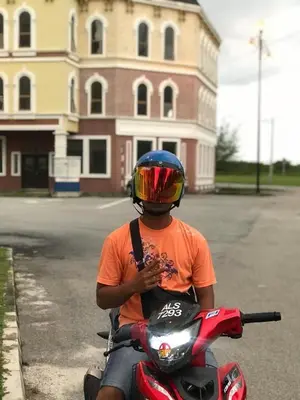 a man riding a red motorcycle with a helmet on at Muhammad Najmi Hakim Bin Abdullah in Kampar