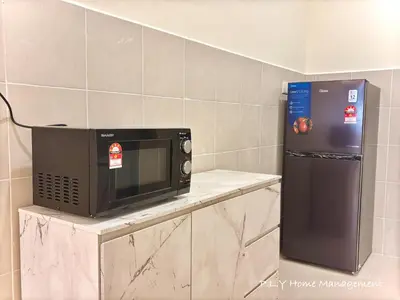 a microwave sitting on a counter next to a refrigerator at Falim Residence Condo Ipoh with 2 Parking in Ipoh