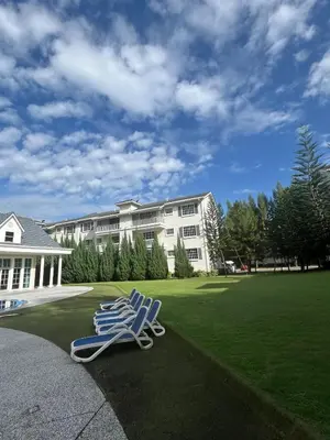 two blue chairs sitting on the grass in front of a building at The Trails Of Kampar in Kampar