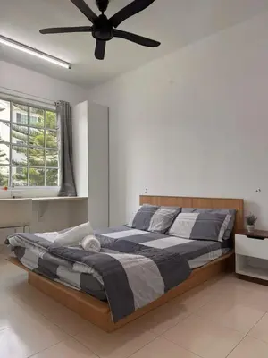 a bedroom with a large bed with a ceiling fan at The Trails Of Kampar in Kampar