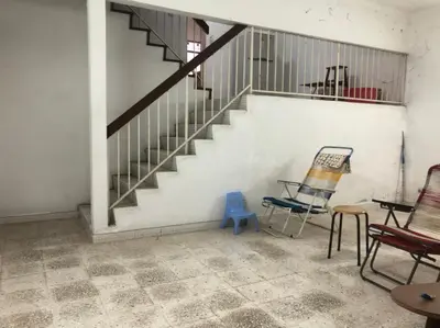 a room with a staircase and a blue chair at Rumah Teres Teluk Kumbar in Bayan Lepas
